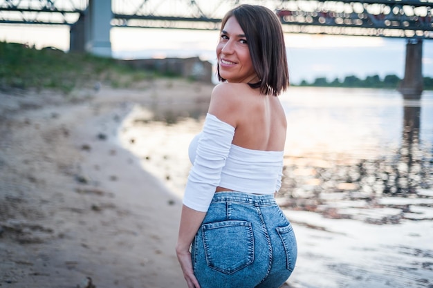 Ragazza che cammina sulla spiaggia contro il tramonto