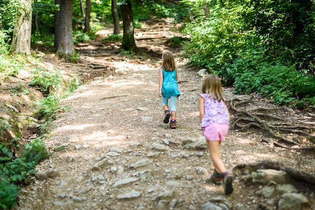 Ragazza che cammina sulla strada in mezzo agli alberi