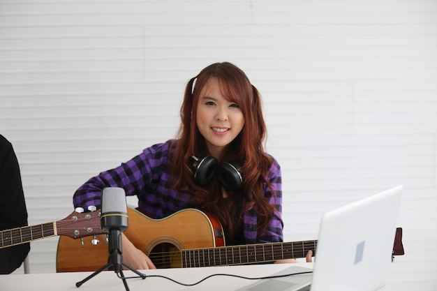 Ragazza che canta al microfono e suona la chitarra