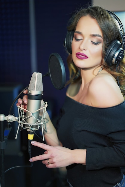 Ragazza che canta al microfono in uno studio