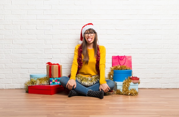 Ragazza che celebra le feste di Natale che mostra la lingua alla macchina fotografica che ha sguardo divertente