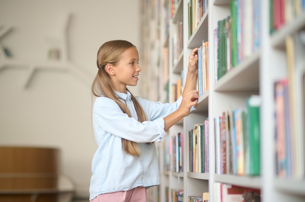 Ragazza che cerca i libri giusti