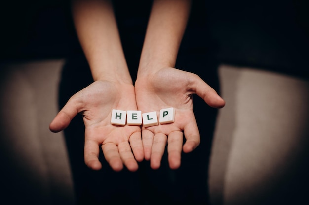 Ragazza che chiede aiuto Ragazza allunga le mani con la parola aiuto nei palmi delle mani