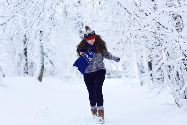 Ragazza che corre nel parco invernale in vacanza sulla neve