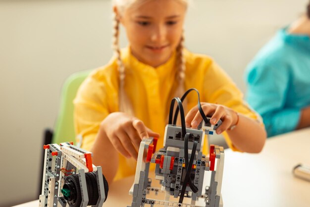 Ragazza che costruisce un robot durante la sua lezione di scienze