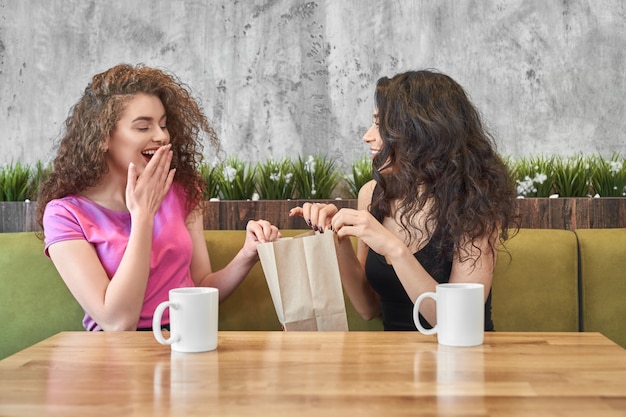 Ragazza che dà presente ad un amico sorpreso nella caffetteria.