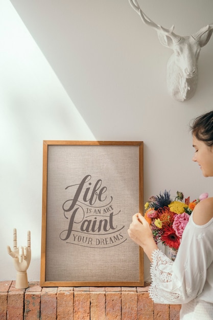 Ragazza che decora una parete con una cornice motivazionale