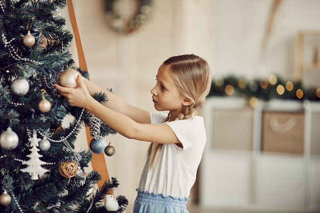 Ragazza che esamina l'albero di Natale