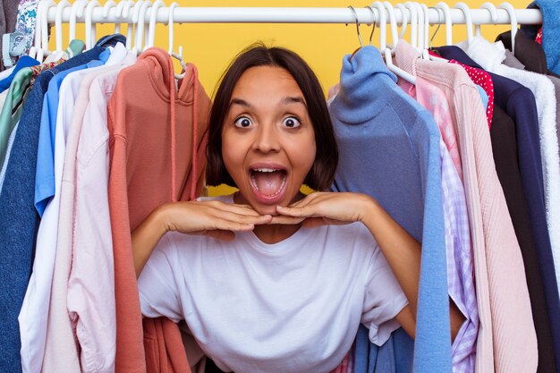 Ragazza che esce da un attaccapanni isolato sulla parete gialla