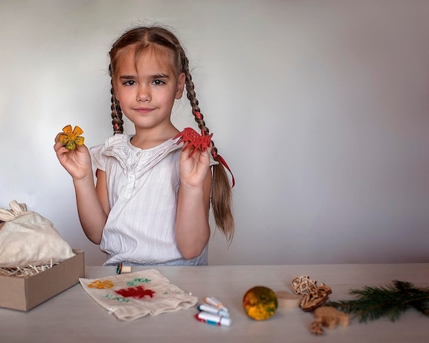 Ragazza che fa confezioni artigianali per regali festivi con tecnica di stampa di francobolli