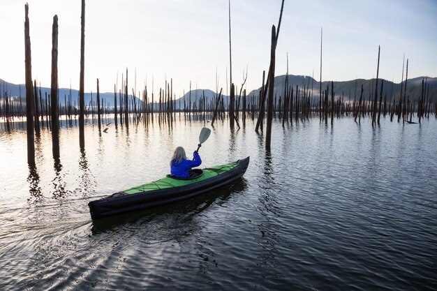 Ragazza che fa kayak in un lago