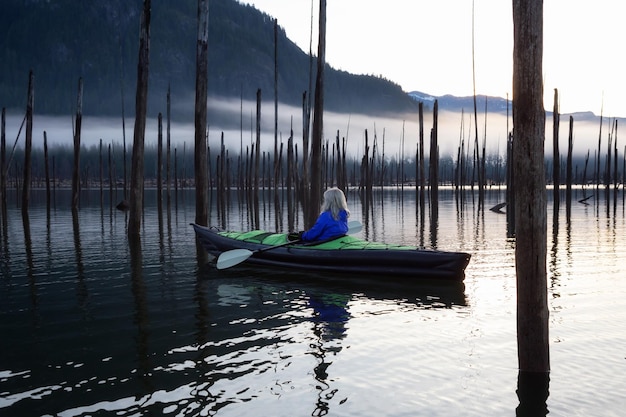 Ragazza che fa kayak in un lago