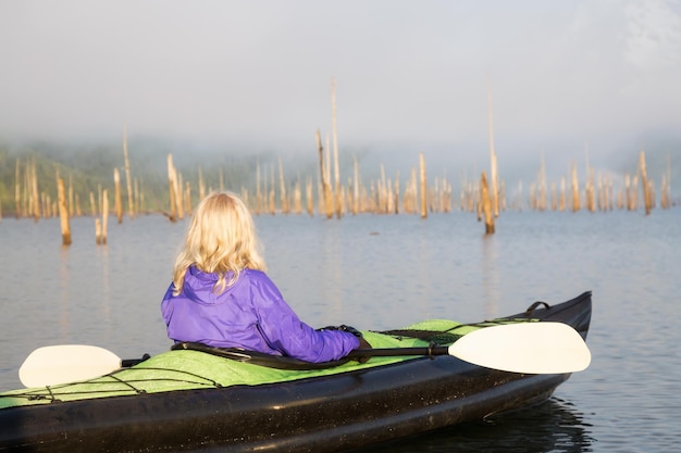 Ragazza che fa kayak in un lago