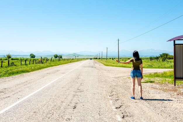 Ragazza che fa l'autostop in un giorno d'estate