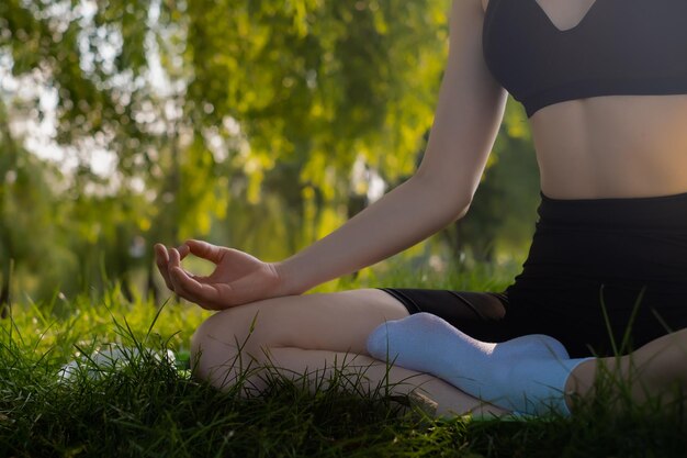 ragazza che fa lezioni di yoga in natura primo piano delle gambe sul tappetino da yoga concetto di calma e meditazione