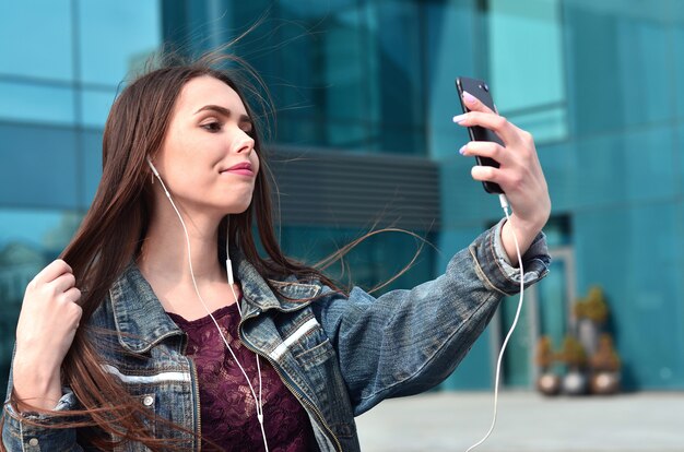 Ragazza che fa selfie sullo sfondo di un edificio per uffici