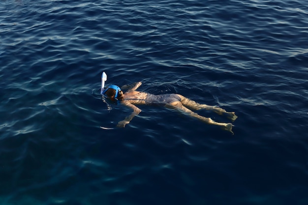 Ragazza che fa snorkeling nel mare blu