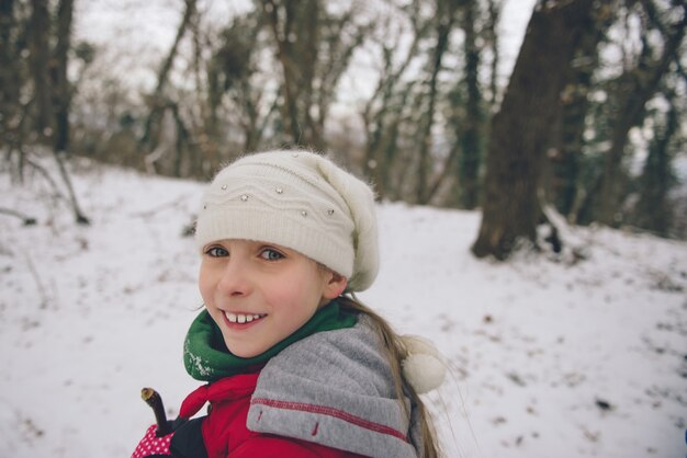 Ragazza che fa un'escursione nella foresta bianca di inverno