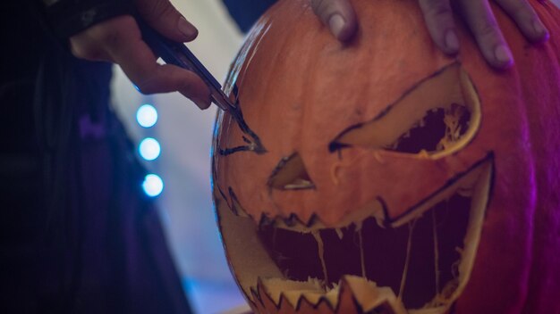 Ragazza che fa una zucca di Halloween