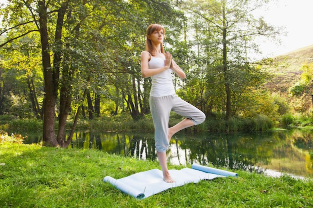 Ragazza che fa yoga nel parco