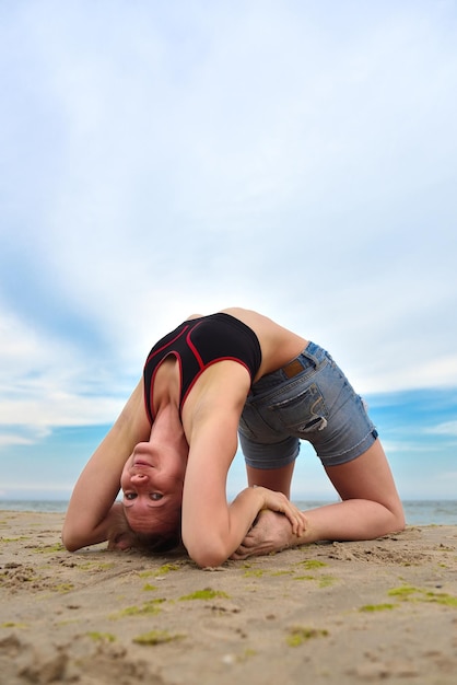 Ragazza che fa yoga sulla costa