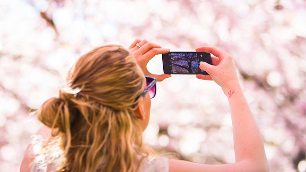 Ragazza che fotografa i ciliegi giapponesi in Danimarca