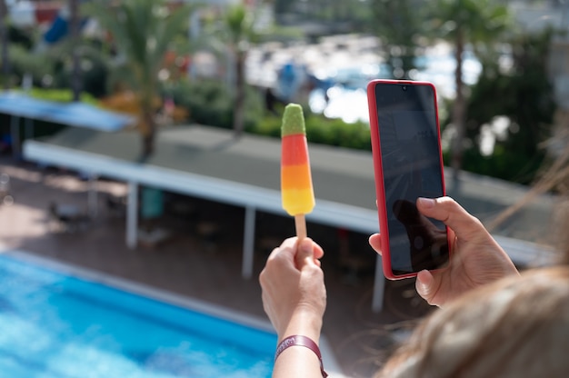 Ragazza che fotografa il gelato al telefono.