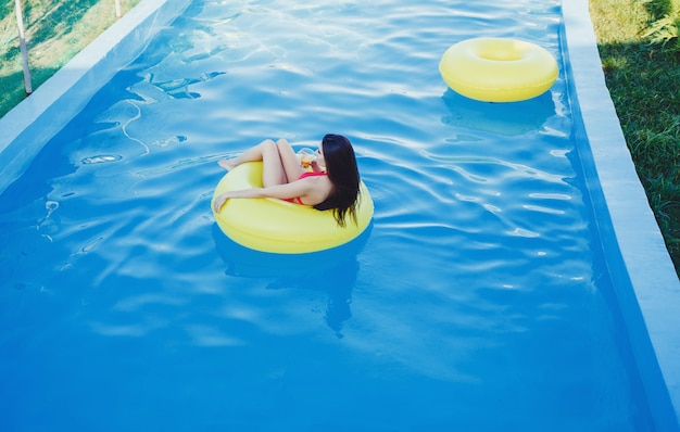 Ragazza che galleggia sul materasso della spiaggia