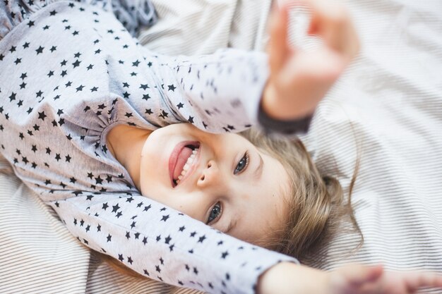 Ragazza che gioca a letto a casa durante il Natale