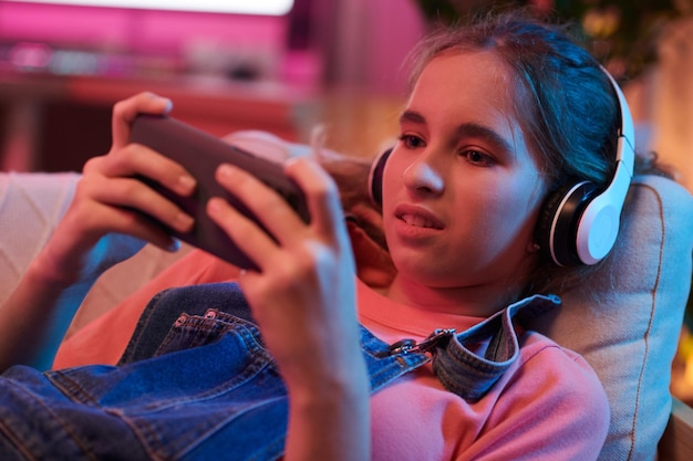 Ragazza che gioca al videogioco sullo smartphone