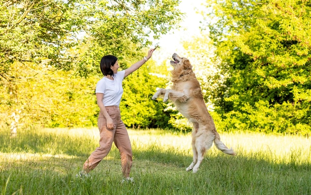 Ragazza che gioca con il cane golden retriever all'aperto