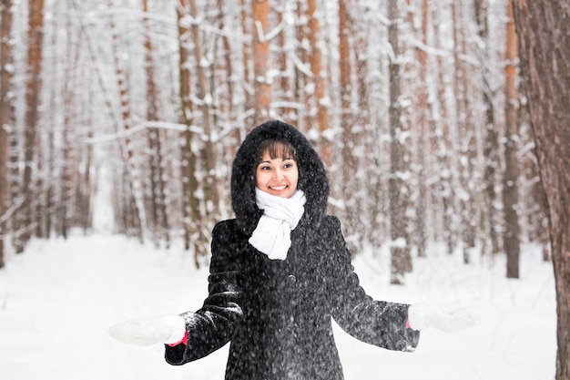 Ragazza che gioca con la neve nel parco invernale.