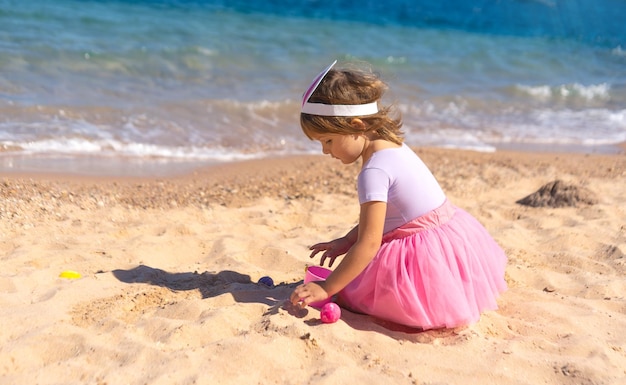 Ragazza che gioca con le uova di Pasqua sulla spiaggia