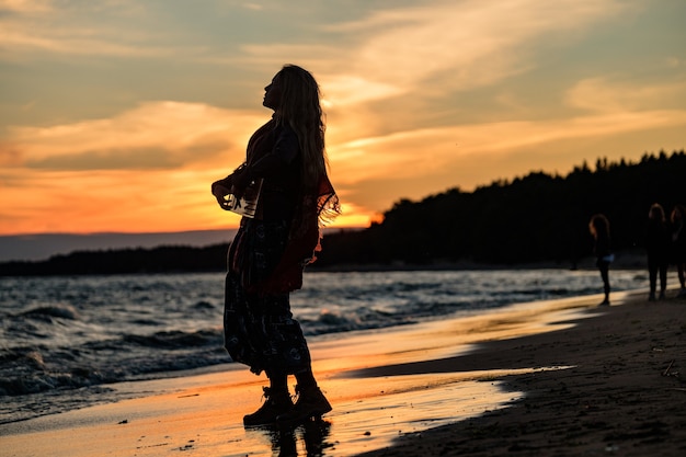 Ragazza che gioca il gusli sulla riva del Golfo di Finlandia.