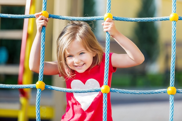 Ragazza che gioca nel parco giochi nel parco cittadino