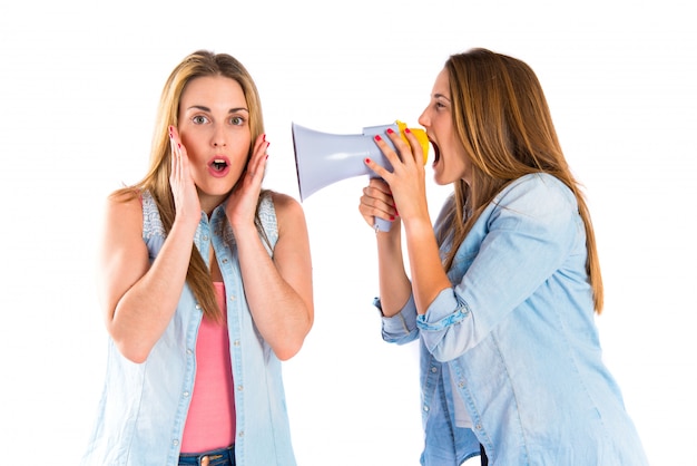 Ragazza che grida con un megafono alla sua amica