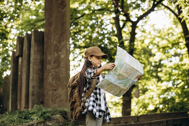 Ragazza che guarda la mappa mentre si cammina nella foresta