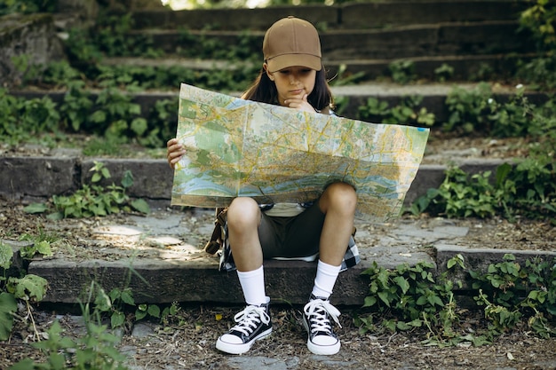 Ragazza che guarda la mappa mentre si cammina nella foresta