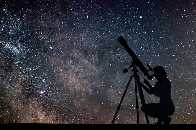 Ragazza che guarda le stelle con il telescopio. Galassia della Via Lattea.