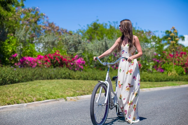 Ragazza che guida una bici sulla località di soggiorno tropicale