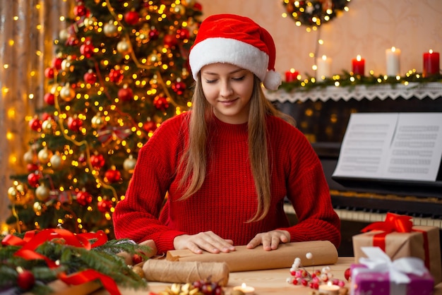 Ragazza che imballa scatole regalo di Natale e realizza decorazioni per la casa Buon Natale e felice anno nuovo concetto