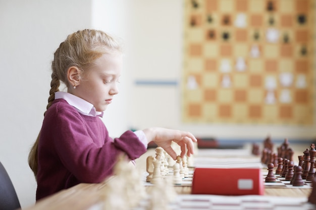 Ragazza che impara la strategia di scacchi