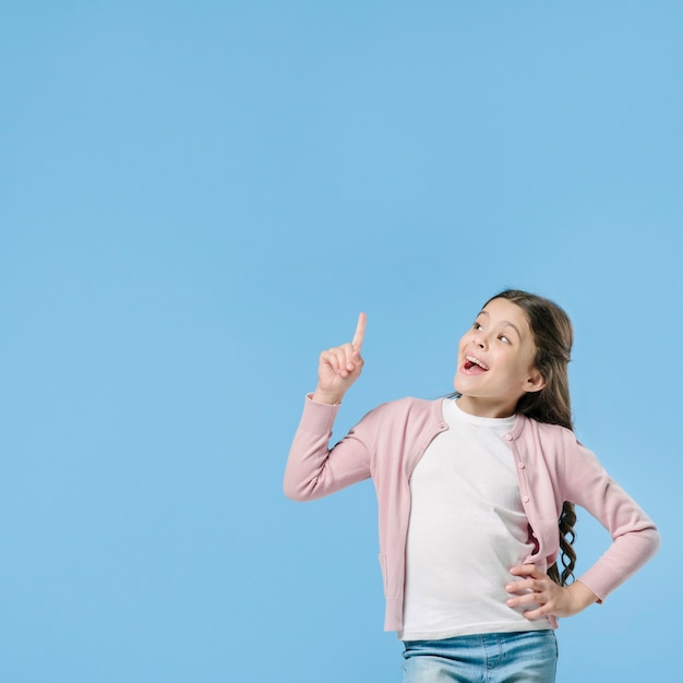 Ragazza che indica in piedi in studio