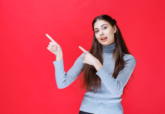 Ragazza che indica qualcosa sul lato sinistro.