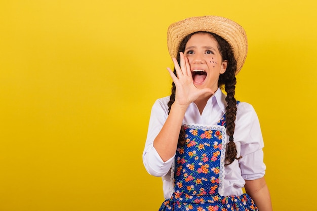 Ragazza che indossa abiti tipici per Festa Junina promozione urlando vendita urlante Per il Festival do Arraia