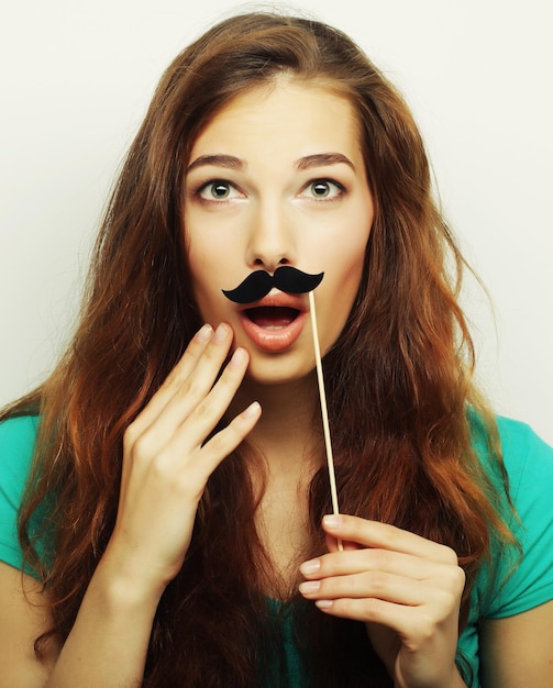 Ragazza che indossa baffi finti. Pronto per la festa.