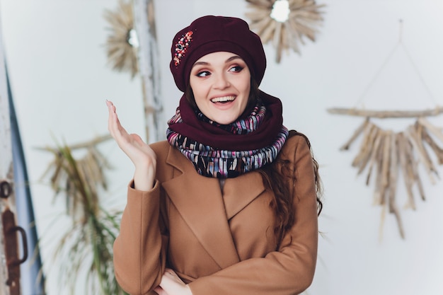 Ragazza che indossa cappello, cappotto e sciarpa caldi lavorati a maglia