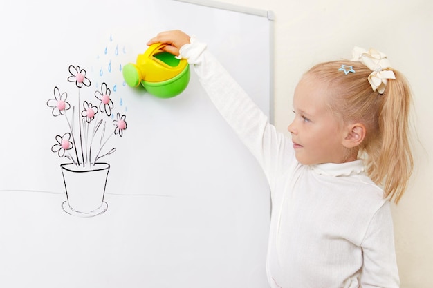 Ragazza che innaffia il fiore che attinge un bordo bianco