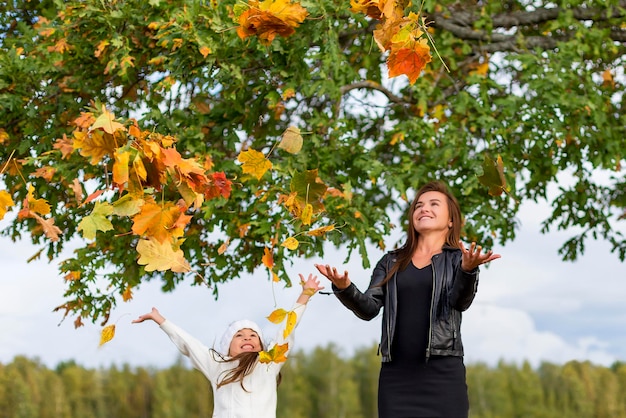 Ragazza che lancia le foglie di autunno