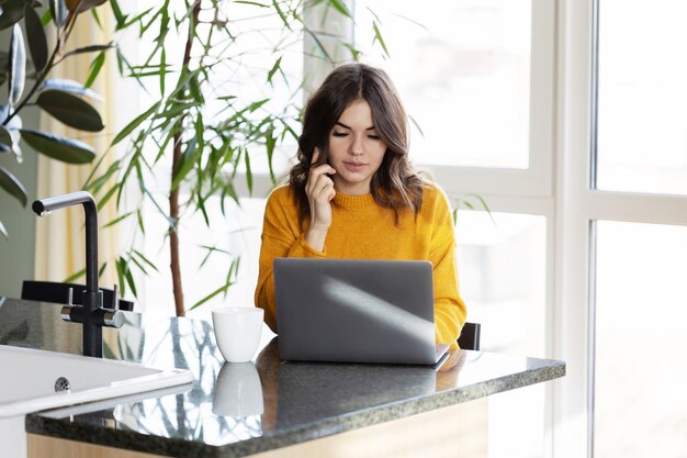 Ragazza che lavora a casa con un laptop durante la quarantena